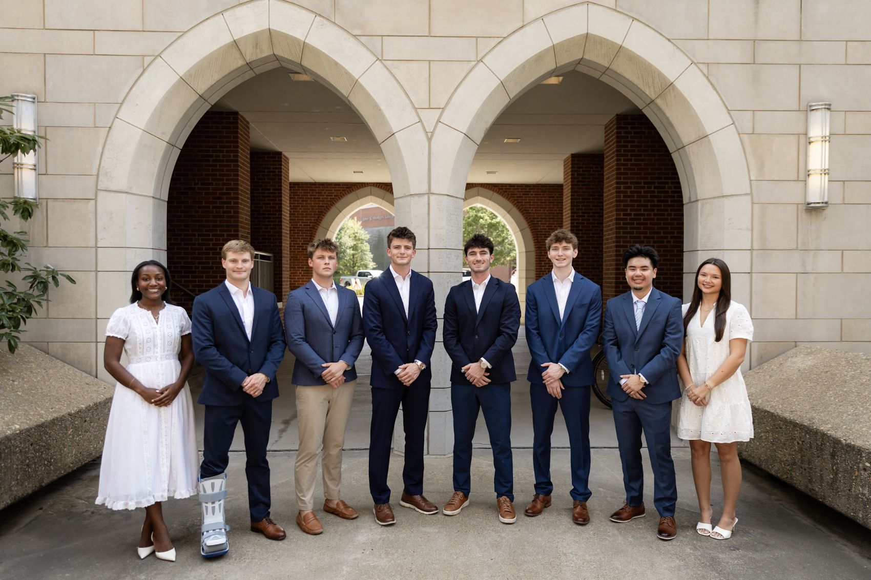 The RecUTK executive board in suits under the stone arches on campus